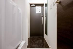东京FL Residence Jingu Gyoen IV的一间带步入式淋浴间和门的浴室