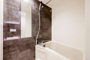 东京FL Residence Jingu Gyoen IV的带淋浴、卫生间和镜子的浴室