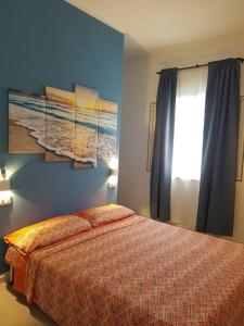 托雷奇安卡Casa Vacanza Villa Stefy - Salento的一间卧室设有一张床和蓝色的墙壁
