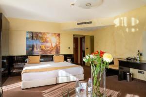 索非亚欧洲酒店的卧室配有一张床,墙上挂有绘画作品