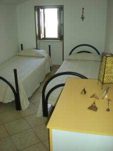 塔维亚诺Casa Bella Vista的客房设有两张床、一张桌子和一扇窗户。