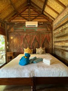 吉利阿尔Al-Shifa Healing House Lombok的木房的一张床位,上面有两袋