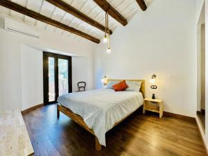 圣塔克里斯蒂纳阿鲁Agudes CostaBravaSi的一间铺有木地板的白色卧室,配有一张床