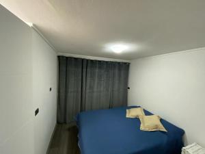 圣地亚哥Ñuñoa, Bello departamento, La mejor ubicacion的一间白色客房内的蓝色床卧室
