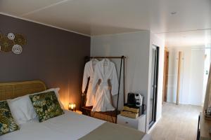 毕博纳的码头卡萨帝卡恰营地旅馆的一间卧室配有一张床,墙上挂着一个长袍
