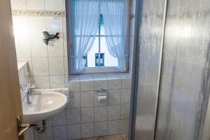 加尔米施-帕滕基兴Gästehaus Quirin的一间带水槽和淋浴及窗户的浴室