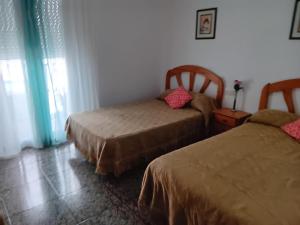 丘利利亚La Replaceta的一间卧室设有两张床和窗户。