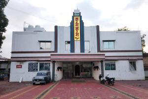 PannaHotel Kumkum Chhaya的前面有停车位的建筑