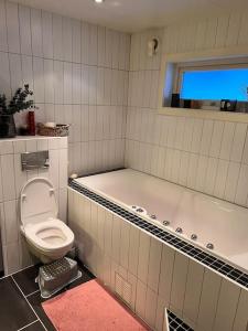 特罗姆瑟Tromsø’s best location? City & Nature 5 mins away.的一间带卫生间和浴缸的浴室