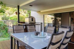 Kin Kinkin kin cottage, Noosa hinterland, walk to town.的一个带厨房的庭院内的桌椅