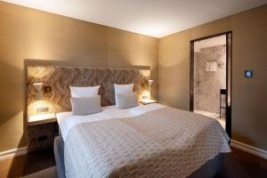 哥本哈根Hypernym Hotel & Suites的一间卧室配有一张带两盏灯的大型白色床。