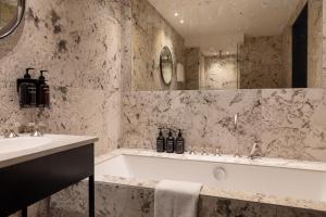 哥本哈根Hypernym Hotel & Suites的带浴缸和盥洗盆的浴室