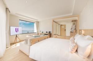 佛丕U Hua Hin的卧室配有白色的床和平面电视。