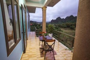 峰牙Phong Nha Cherish House的设有一个配有桌椅并享有美景的阳台。
