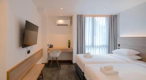 曼谷ZEN MASTER HOTEL的酒店客房设有两张床和电视。