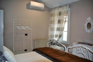 科莫宝石之家公寓的一间卧室设有一张床和一个窗口