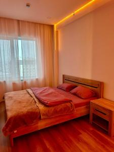 乌兰巴托Exclusive USA Embassy Proximity Apartments的一间卧室配有一张带窗户和木制床架的床