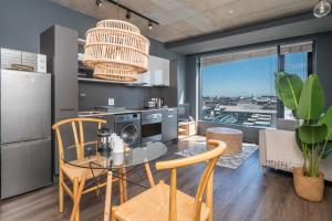 开普敦Modern and New with Harbour View的厨房以及带玻璃桌和椅子的客厅。