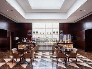 沙迦Four Points by Sheraton Sharjah的一间带桌椅和柜台的餐厅