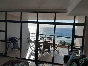 拉莫西CoRAL REEF 207的一间带桌椅和海洋的客厅