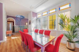 阿亚蒙特Casa Verde Ayamonte的一间设有玻璃桌和红色椅子的用餐室