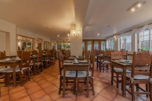 拉戈斯Charming Residence & Guest House Dom Manuel I Adults only的餐厅设有木桌、椅子和窗户。