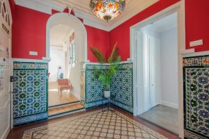 阿亚蒙特Casa Verde Ayamonte的一间设有红色墙壁的房间和一个带盆栽的走廊