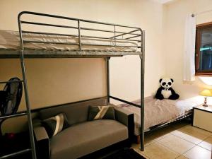PaïtaMaison en bois au Mont mou的一间卧室配有一张双层床和熊猫玩具