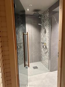 贝特斯托尔Luksus i Riddergaarden的浴室里设有玻璃门淋浴