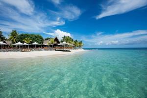放逐岛斐济卡斯特威海岛度假酒店的海滩上,有一把遮阳伞和大海
