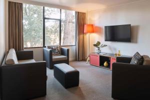 奥尔伯里奥尔伯里阿图拉酒店的客厅配有椅子和平面电视