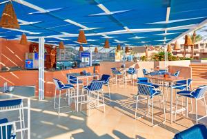 加利布港Pickalbatros Sands Port Ghalib的餐厅拥有蓝色的天花板和桌椅
