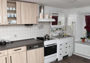 Neuenrade诺伊恩拉德旅馆的厨房配有水槽和炉灶 顶部烤箱