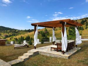 兹拉蒂博尔Zlatibor Sky Inn的凉亭,带桌子和长凳的田野