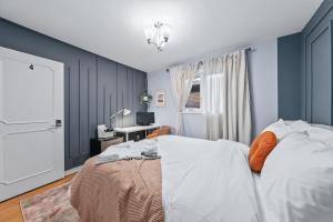 多伦多Large & Sunny Private bedroom in Villa的一间卧室设有蓝色的墙壁和一张带橙色枕头的床