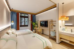 成都熙蜀酒店的酒店客房设有两张床和盥洗盆