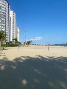 桑托斯Apartamento Frente ao Mar Santos的一片拥有建筑和棕榈树的大型空滩