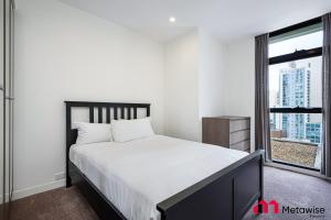 悉尼MetaWise Sydney CBD Haymarket Luxe 2Bed Penthouse Aqua的一间卧室设有一张大床和一个窗户。