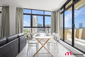 悉尼MetaWise Sydney CBD Haymarket Luxe 2Bed Penthouse Aqua的一间带桌椅的用餐室