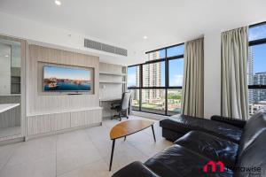 悉尼MetaWise Sydney CBD Haymarket Luxe 2Bed Penthouse Aqua的带沙发和电视的客厅