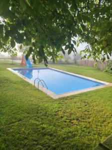 昆卡Estancia Vacacional Las Nogueras的一个带草地的庭院内的游泳池