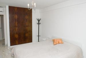 马托西纽什波尔图赛公寓的卧室配有白色的床和橙色枕头