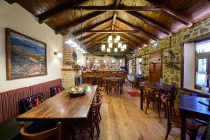 奥吉欧司吉玛洛斯Agios Germanos的一间带木桌椅的餐厅和一间酒吧
