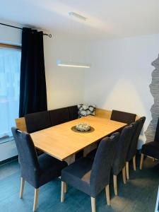 厄茨Ferienhaus Julia的一间带木桌和椅子的用餐室