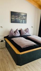厄茨Ferienhaus Julia的床上铺有紫色枕头的床