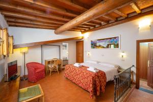 佛罗伦萨城市酒店的一间卧室配有一张大床和一张红色椅子