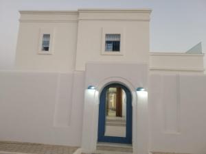 米多恩Diar Nader的白色建筑的入口,有蓝色的门