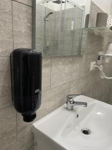 那不勒斯Garibaldi guest house的浴室水槽和墙上的肥皂分配器