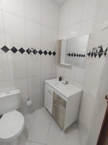 伊塔佩马Casa Aconchegante em Itapema的白色的浴室设有卫生间和水槽。