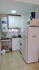 罗萨里奥莫雷诺1330公寓的厨房配有白色橱柜和白色冰箱。